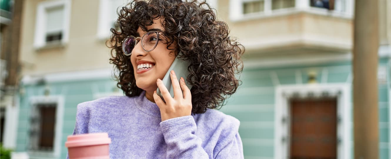 Curly hair woman smiling and talking at the phone