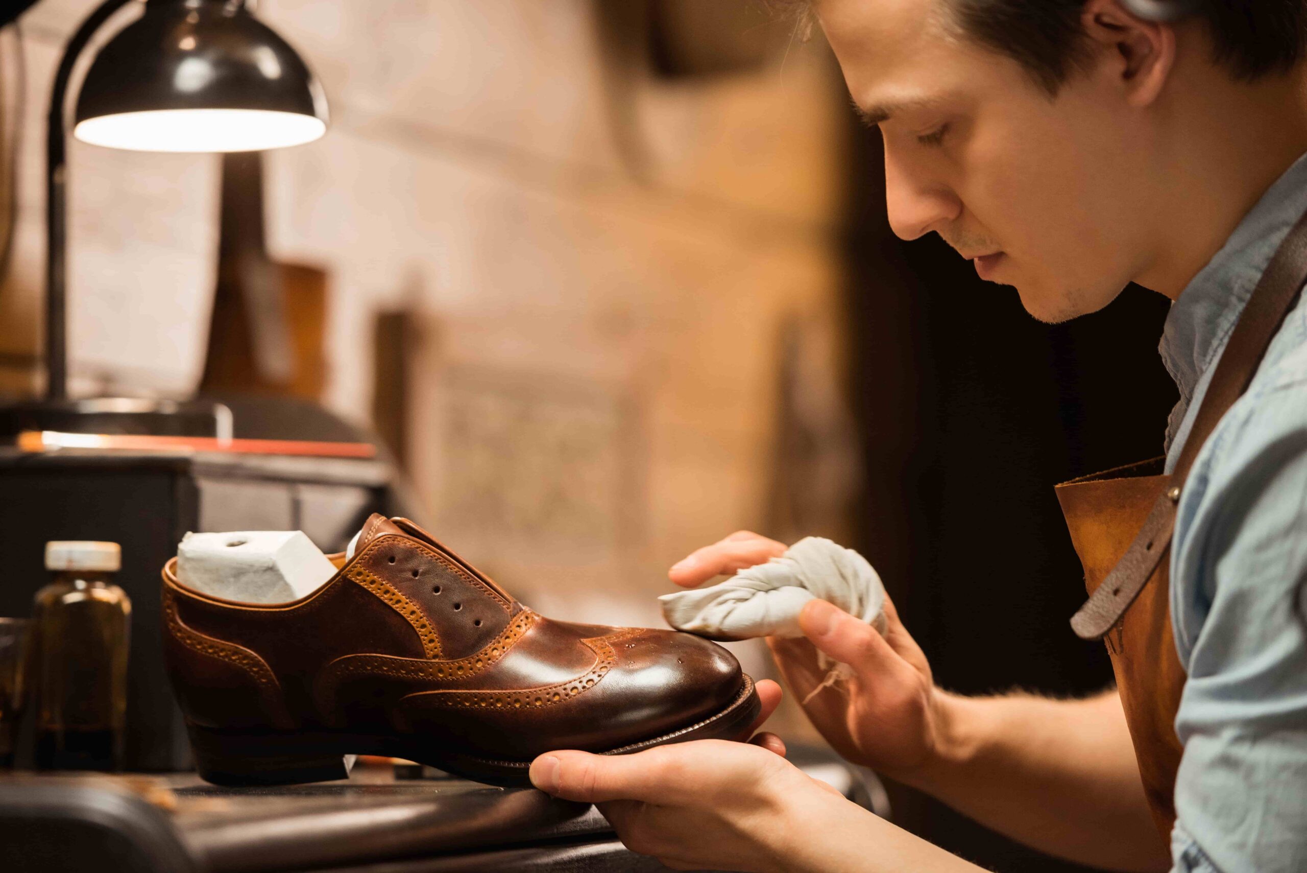 fine shoemaker cleaning a leather shoe for man