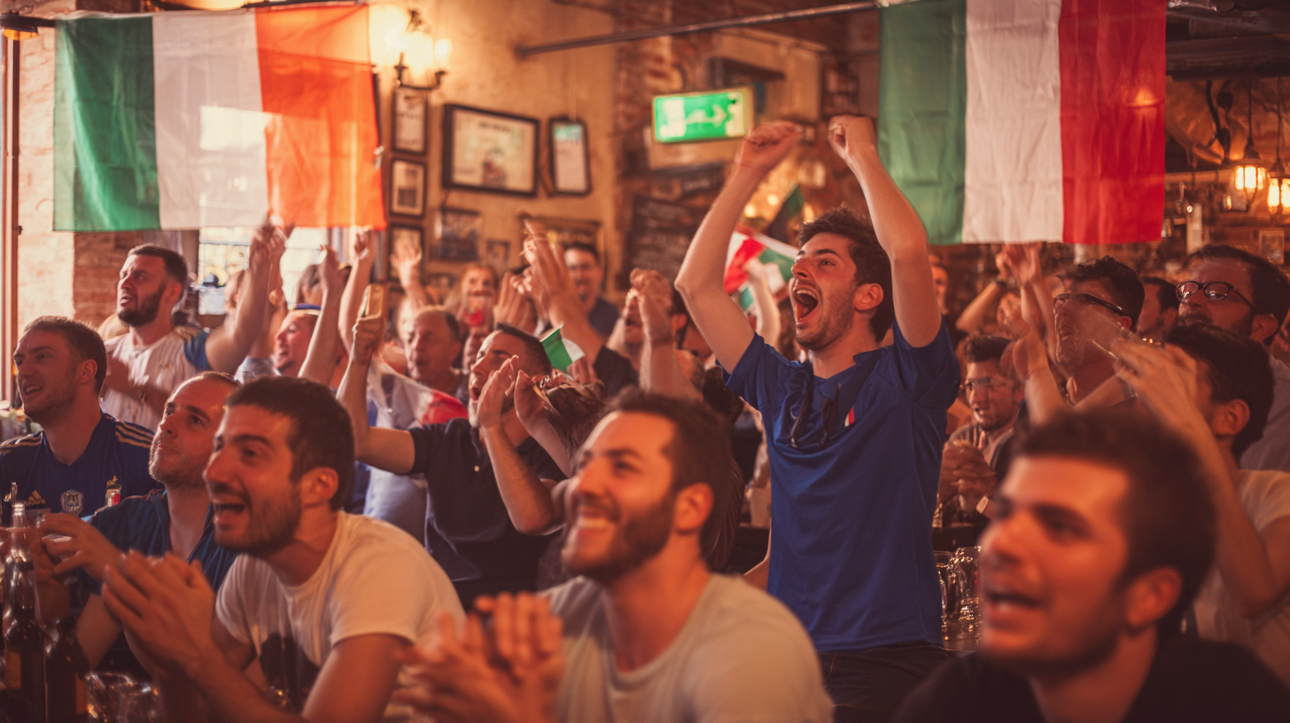 Football fans celebrating together while watching an international soccer match in a pub decorated with Italian flags.